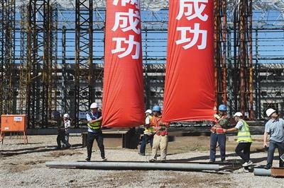 昨日，工作人员在为钢结构屋顶最后的一次提升做准备。 上午10时37分，北京新机场南航基地1号机库7200吨的钢结构屋架成功提升就位，标志着这座亚洲最大机库封顶。新京报记者 吴江 摄