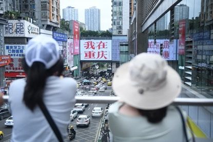 图为游客在重庆观音桥商圈“我在重庆”大屏幕前拍照。 图为游客在重庆观音桥商圈“我在重庆”大屏幕前拍照。